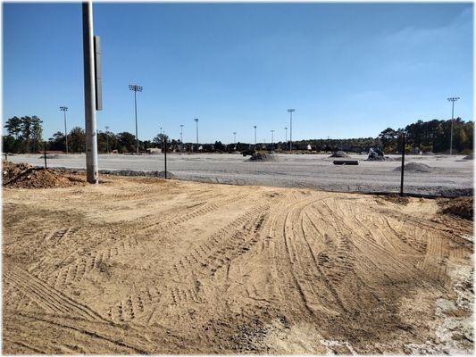 This was recently unspoiled woods. Then it became a grass athletic field. Now it's about to be a gravel lot covered with plastic grass. Sad.