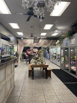 Bridal area and flower arrangements in cases.