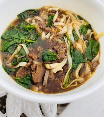 Homemade beef tendon noodle soup with fresh spinach