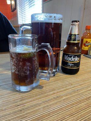 Regular bottle of beer in cold glass next to a jumbo draft beer