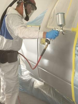 Kevin applying the clearcoat on a silver truck.