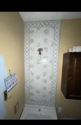 Beautiful mosaic marble accent strip above the vanity for this bathroom