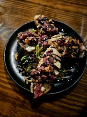 Black & Bleu Bites Fired grilled garlic bread with creamed Bleu cheese, medium rare steak, & fried shallots  DELICIOUS!