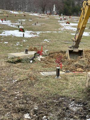 Back hoe in grave of loved one 3 days after burial. Headstone not placed back and spray thrown to side.  Disrespect at its finest.