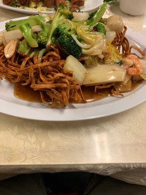 Seafood tender greens over egg noodles