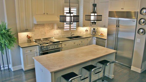 Darker stone on the cabinet countertops, lighter stone on the kitchen island.