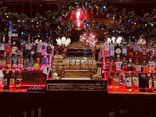 Exquisite cash register dressed for the holidays - surrounded by a full bar offering mid-top shelf adult beverage options.