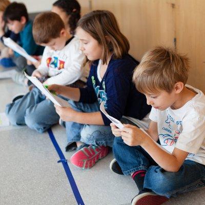 Lower Elementary students learning their lines for an all-school assembly.