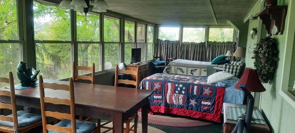 All glassed in upper porch with large dining table and 2 beds.  It's probably our favorite area. Over looking the lake.