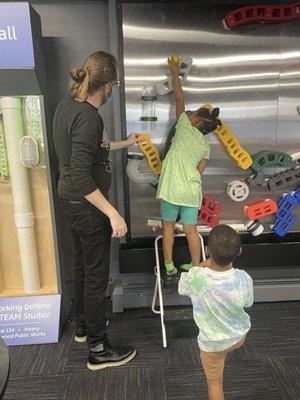 Mr. Charlie working with the little ones in creating a path for the ball to follow once released