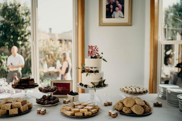 Wedding cake with dessert spread.