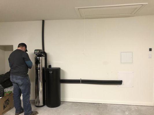 Whole home water filtration system installed in a garage.