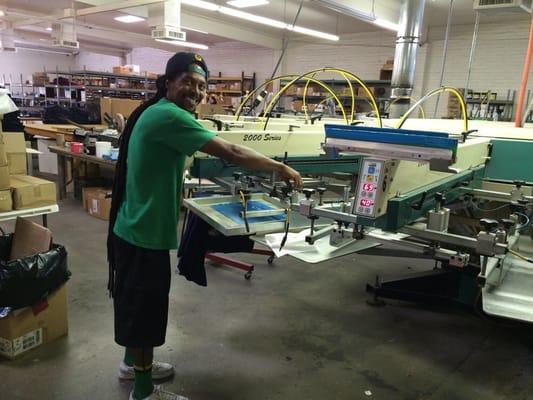 Some of the happiest employees I've ever seen. Prepping the screen printing machine