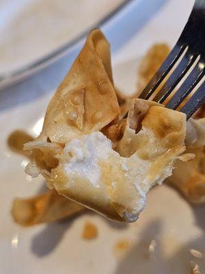 A fork holding a Crab Rangoon appetizer. So fresh and appetizing.