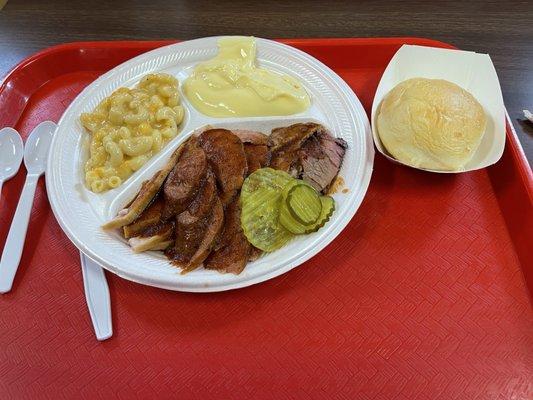 Three meat tray (Brisket, Turkey, Regular Sausage), Mac & Cheese, Banana Pudding, pickles, and Dinner Roll.