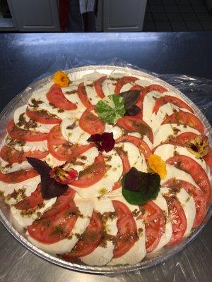 Tomato and fresh mozzarella platter made with edible flowers and fresh opal basil from our Store Garden.