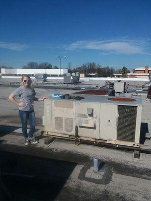 Brooke on top of a roof top building by package unit