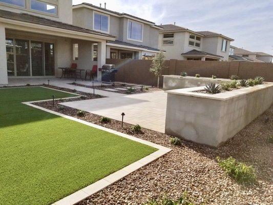 Instead of turf, decorative rock, plants, irrigation, travertine, lighting, concrete planter box