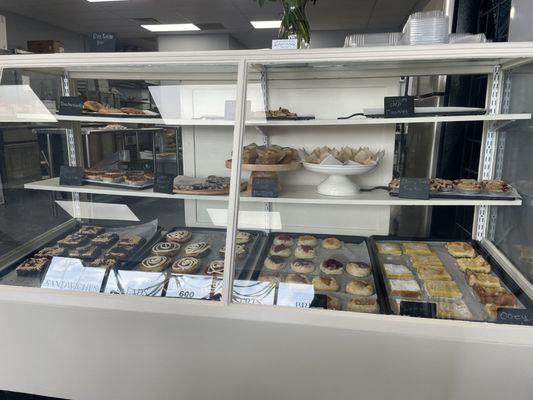 Baked goods cabinet with tiny pies, muffins, scones, and bars