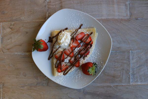 Strawberry Crepe with fresh strawberries, Nutella drizzle, powdered sugar and whipped cream. Also available gluten free.