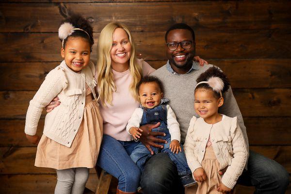 family photographer studio portraits Portsmouth New Hampshire smiling family of 5 dressed in cream on a wood backdrop