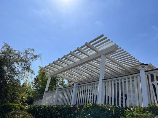 White patio cover with vinyl closed picket with trex accent handrail