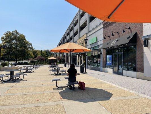 Outdoor patio seating and retail parking garage a few doors down from the bakery (8.24.22)