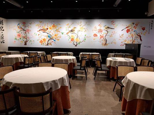 Inside restaurant with beautiful hand painted wall of birds. 15 tables for 4.