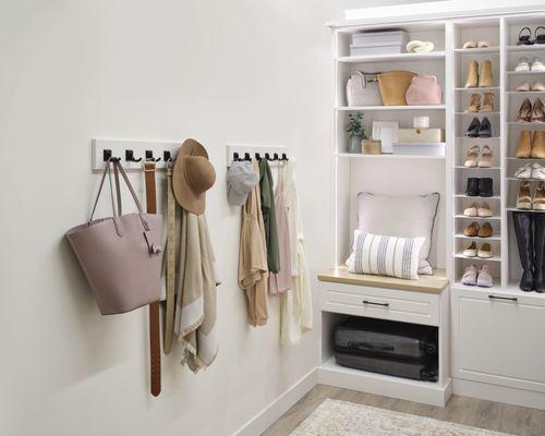 This Arctic White closet Features a sitting area, hamper, a shoe Shrine, and Tunable LED lighting.