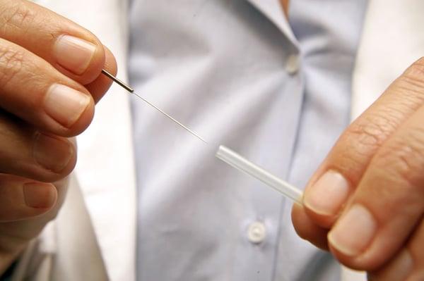 Doctor displaying acupuncture needle.