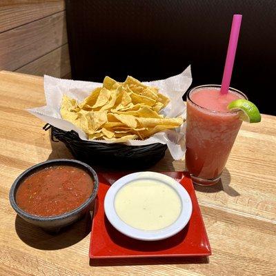 Cheese dip, salsa, chips, and a raspberry marg