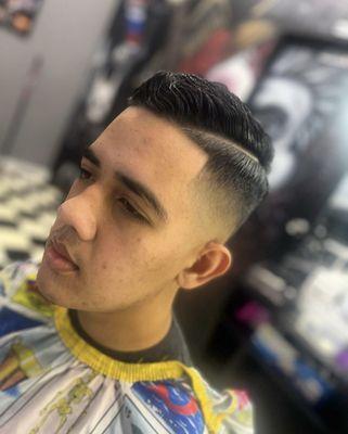 Skin fade comb over with a line up and a part.