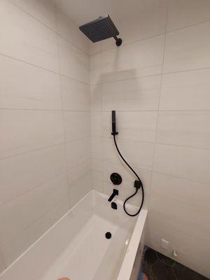 Installing a shower in the bathtub.