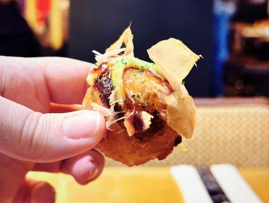 Tako Yaki - fried wheat flour octopus balls with sauces and fish flakes on top.