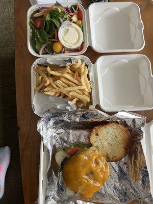 A burger, fries and side salad.