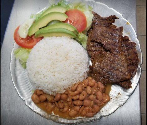 Steak served with Rice, beans, salad and avocado