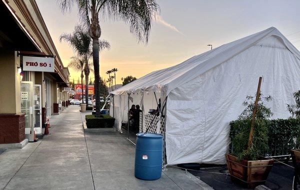 They have a tented extension in front of their restaurant. Tables are spaced apart according to regulations.