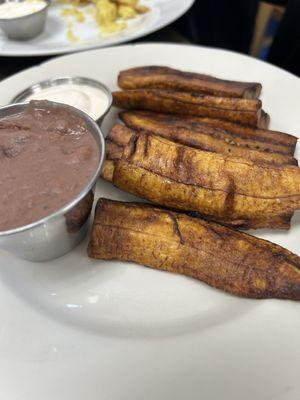 Platanos (sweet plantains) with refried beans and crema (Latin sour cream)