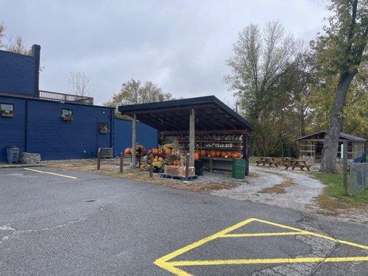 Picnic Tables on the side for outdoor eating. Plus what looks like a fruit stand they're selling pumpkins at.