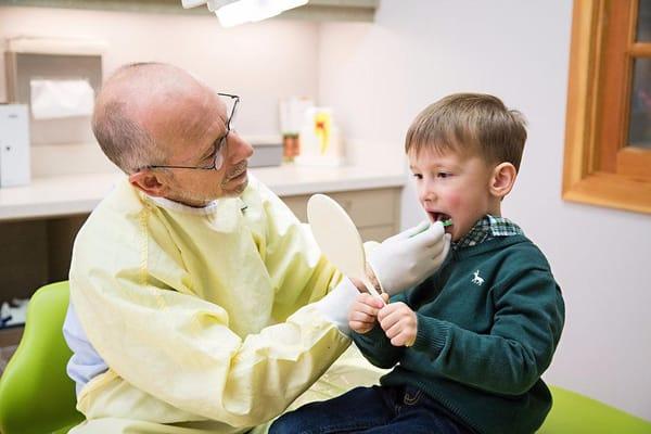 Dr. Aubuchon with a patient showing him how to floss.