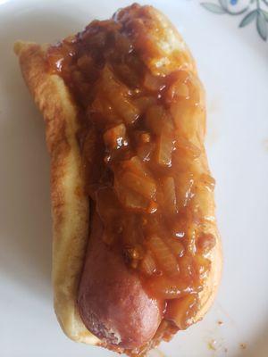 chilli dog with onions, with a few bites taken out.