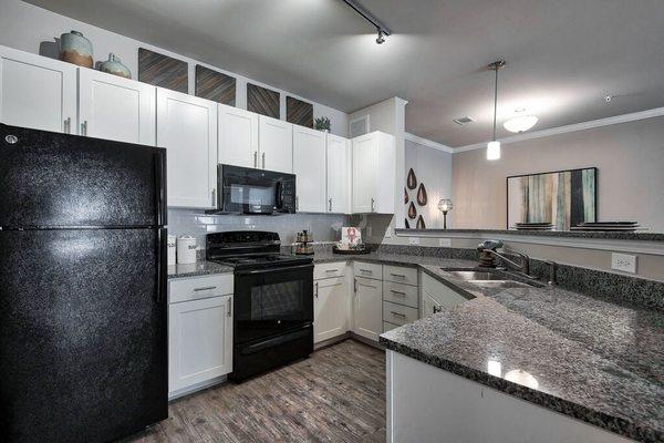 a kitchen with granite counter tops and black appliances at Sterling Creek