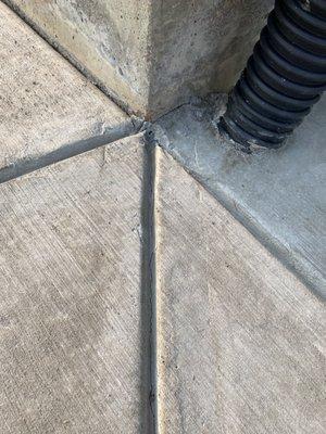 Downspout encased with concrete.