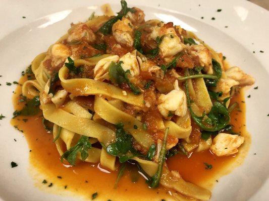 Homemade Fettuccine with Jumbo Lump Crab Meat, Arugula and white wine tomato Sauce.