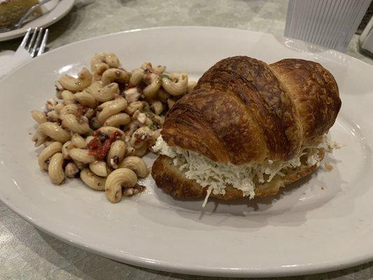 Chicken salad on a croissant with a side of Greek pasta salad