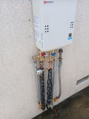 Newly installed tankless water heater and related parts and hardware.