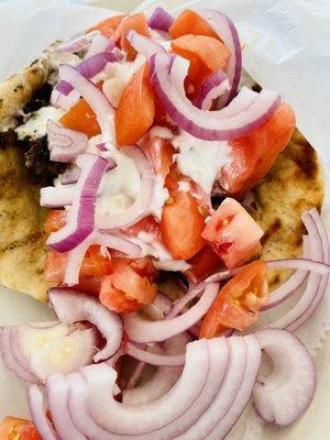 Befteki as it comes to the table. Under the tomatoes and onions is a large burger