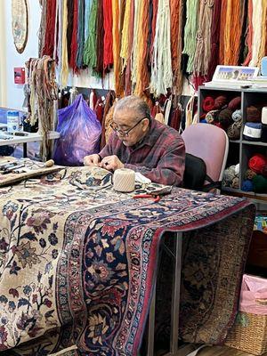 Master weaver restoring a rug