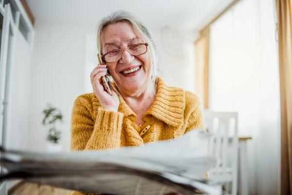 "Joyful Connection: Senior Woman Enjoys a Warm Phone Conversation"