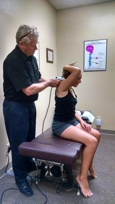 Adjusting the cervical vertebrae. He uses traditional methods as well as The Activator in his treatments.